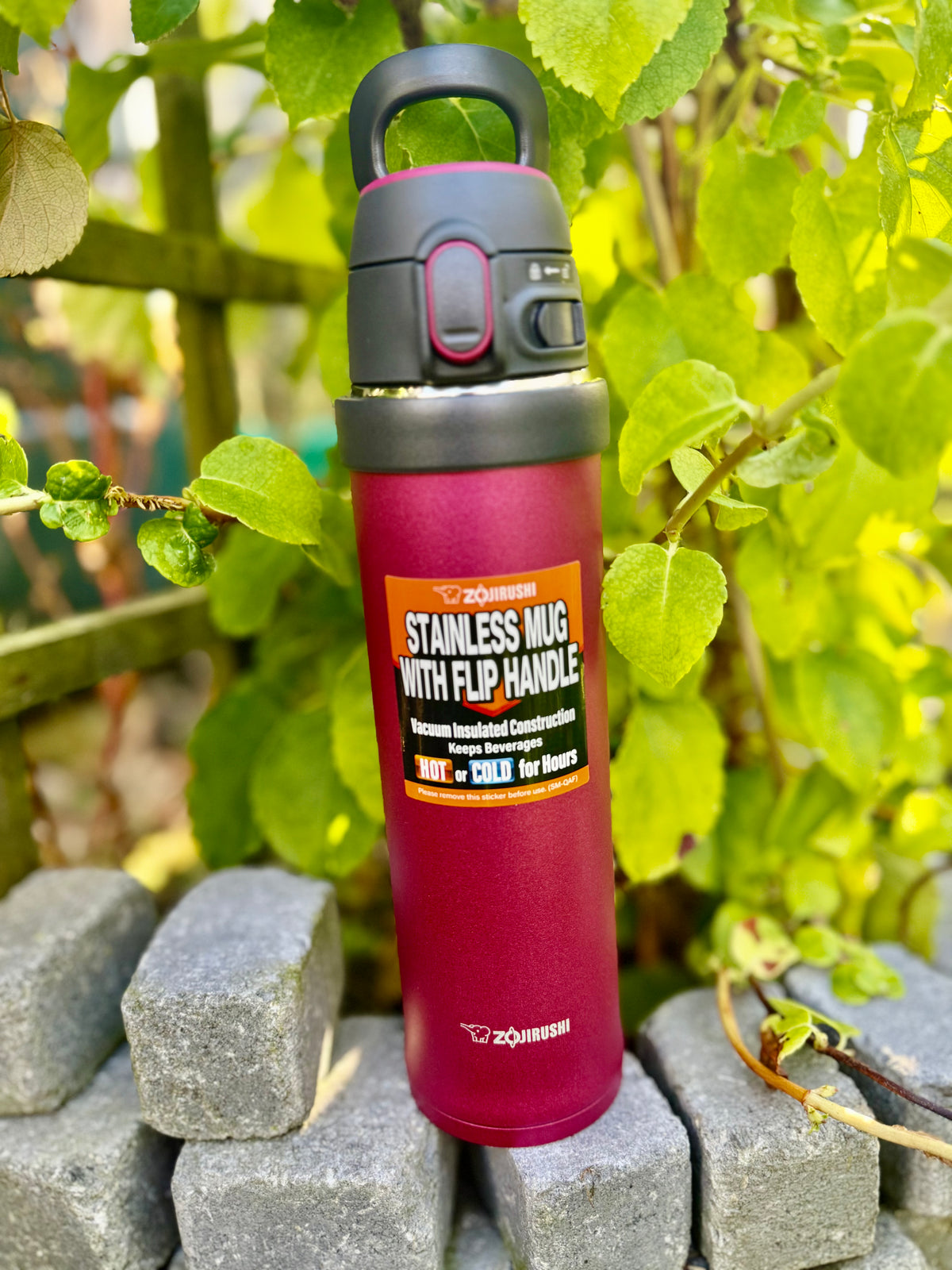 Zojirushi SM-QAF60 Carry Tumbler in Red, 600 ml stainless steel travel mug with flip handle, BPA-free insulated bottle for hot and cold drinks, outdoor lifestyle photo in Ireland